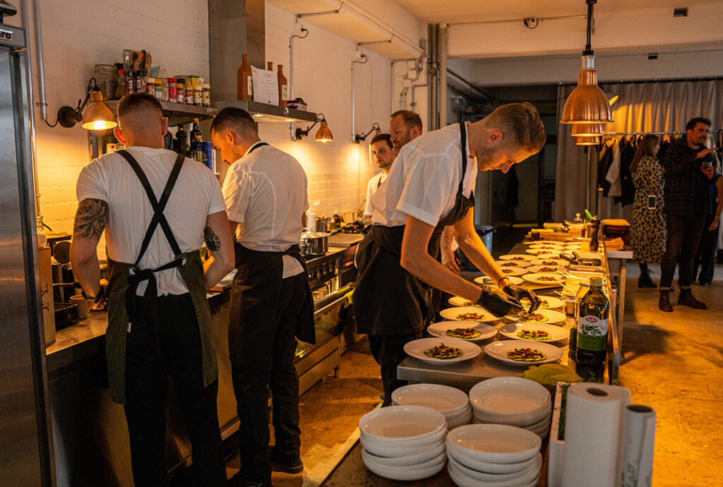 Köche richten Gerichte in belebter Restaurantküche an