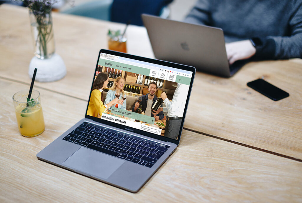 Laptop zeigt ausgehende Pizzeria Webseite auf Holztisch