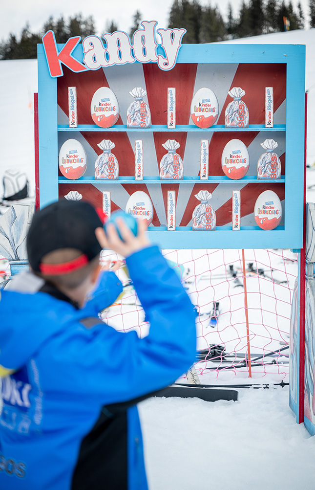 Kind wirft Bälle auf Süßigkeitenstand im Schnee
