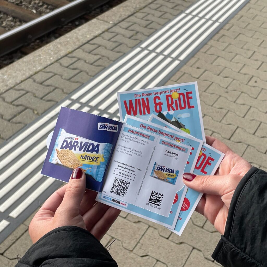 Hände halten Flyer und Tickets am Bahnhof