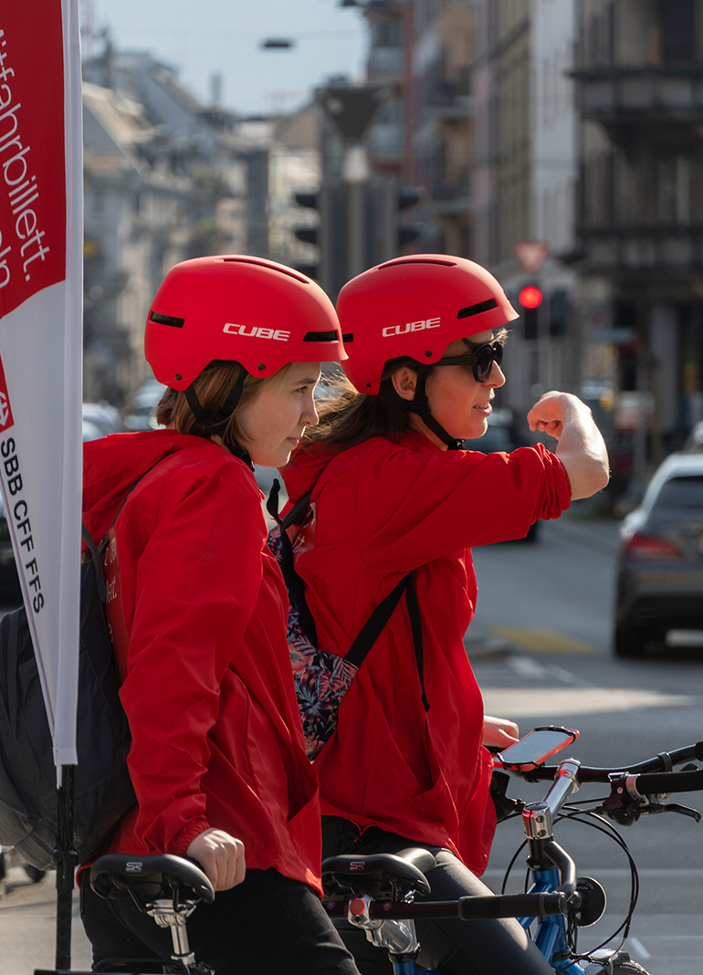 Zwei Radfahrerinnen in Rot zeigen Weg