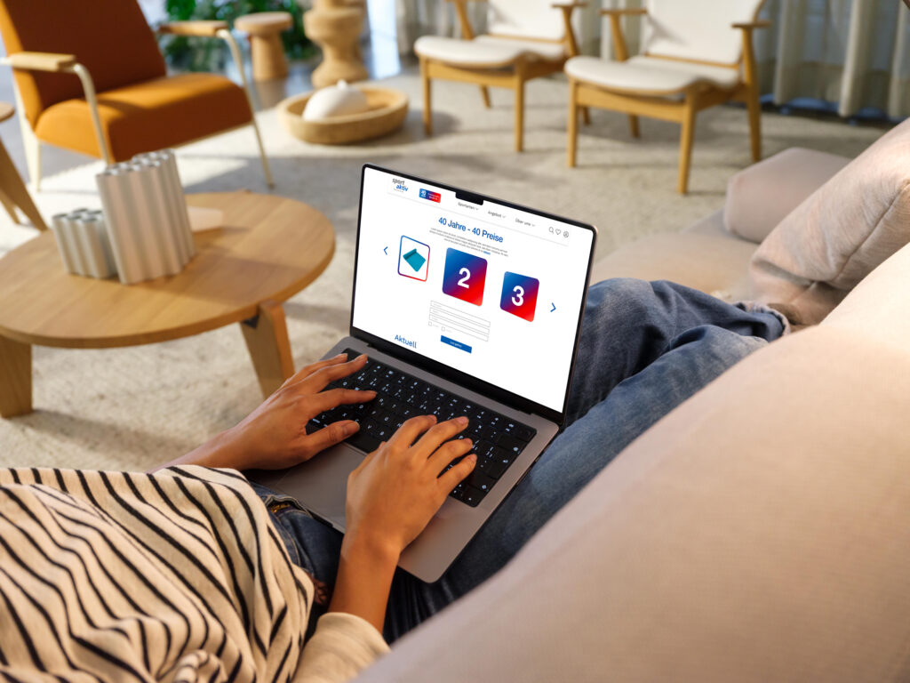 Person arbeitet am Laptop im Wohnzimmer