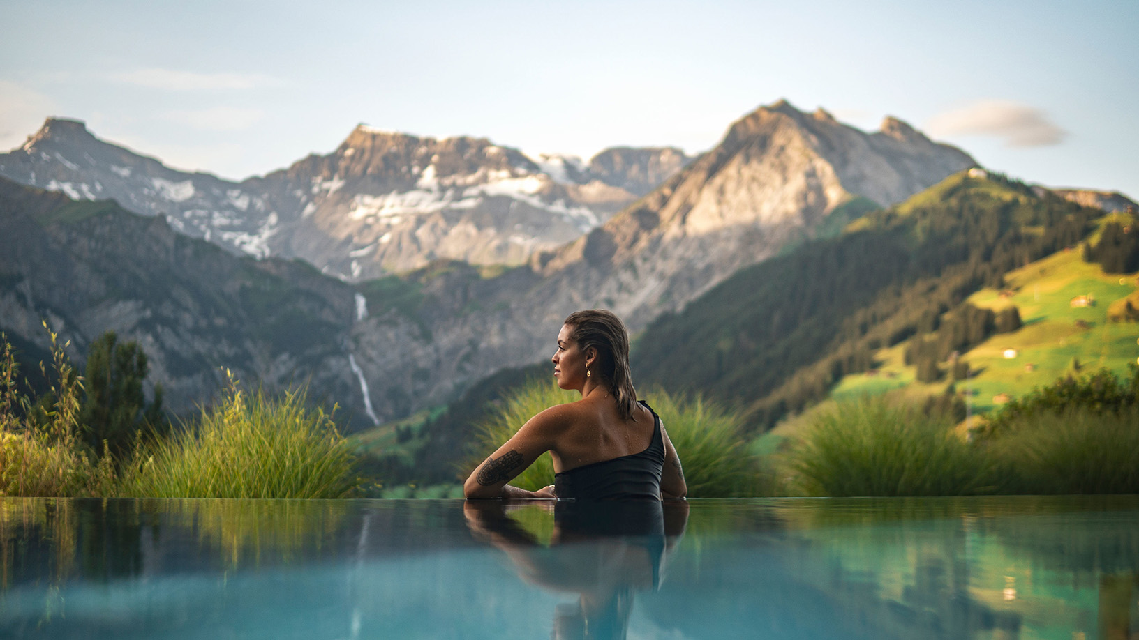 Frau entspannt im Infinity-Pool mit Bergblick