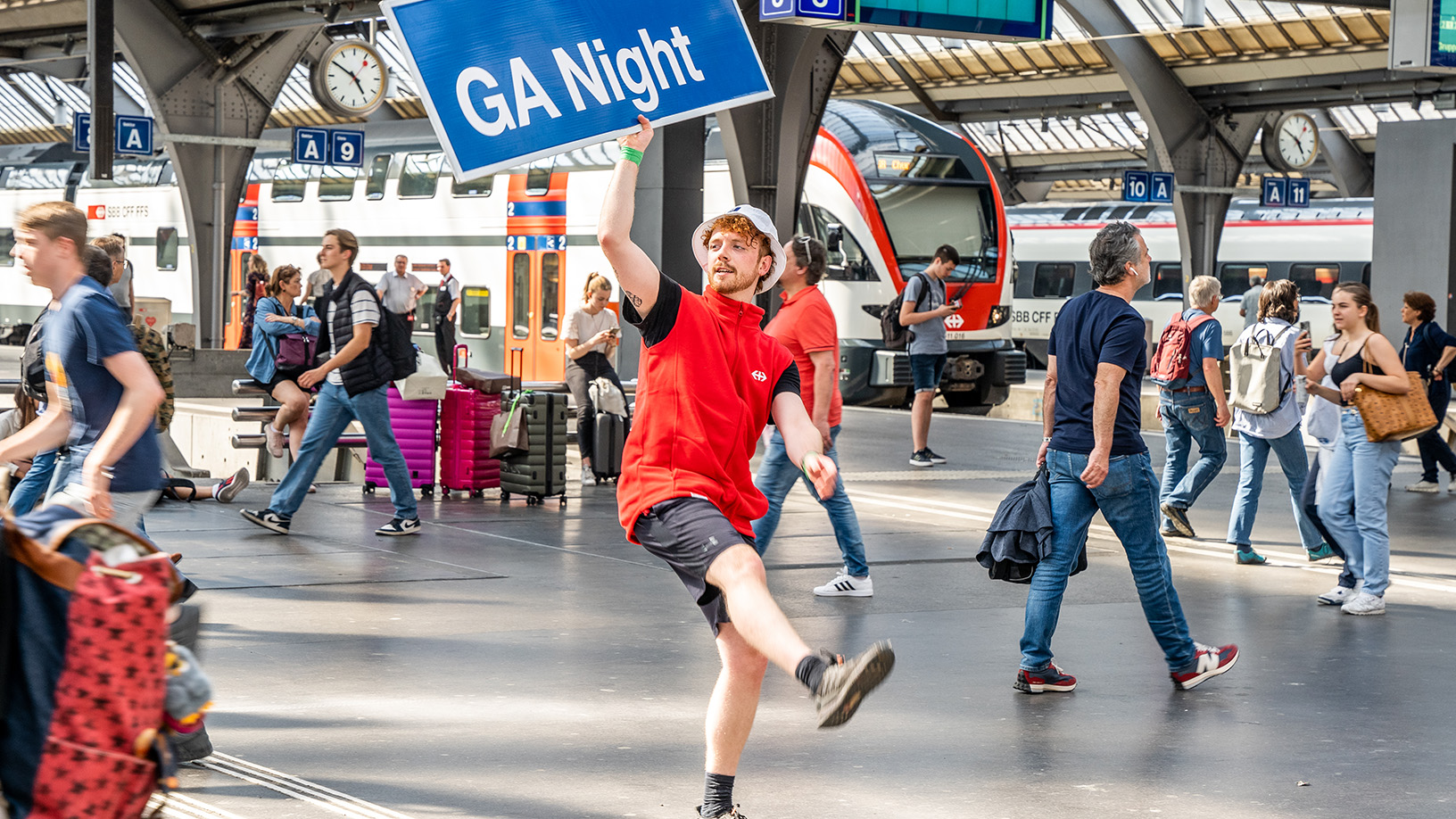 Mann mit Schild am belebten Bahnhof