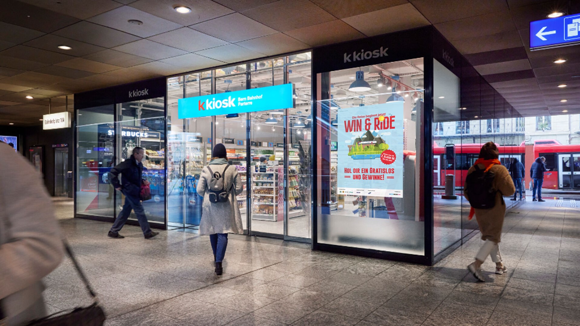 Leute gehen vor Kiosk am Bahnhof