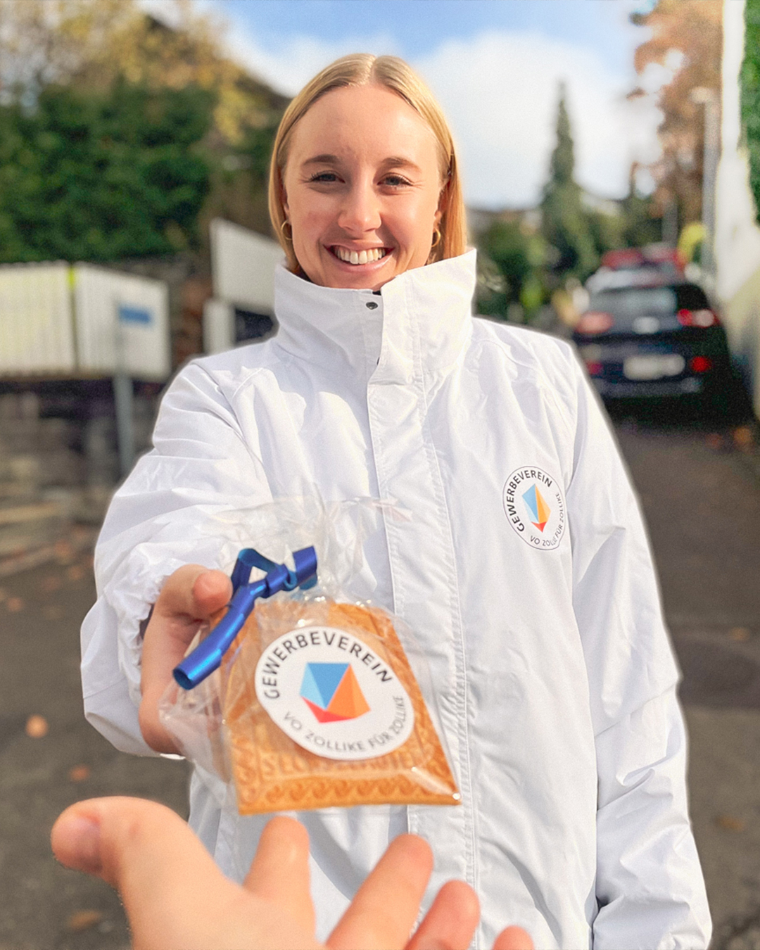 Frau überreicht Preis im Freien lächelnd