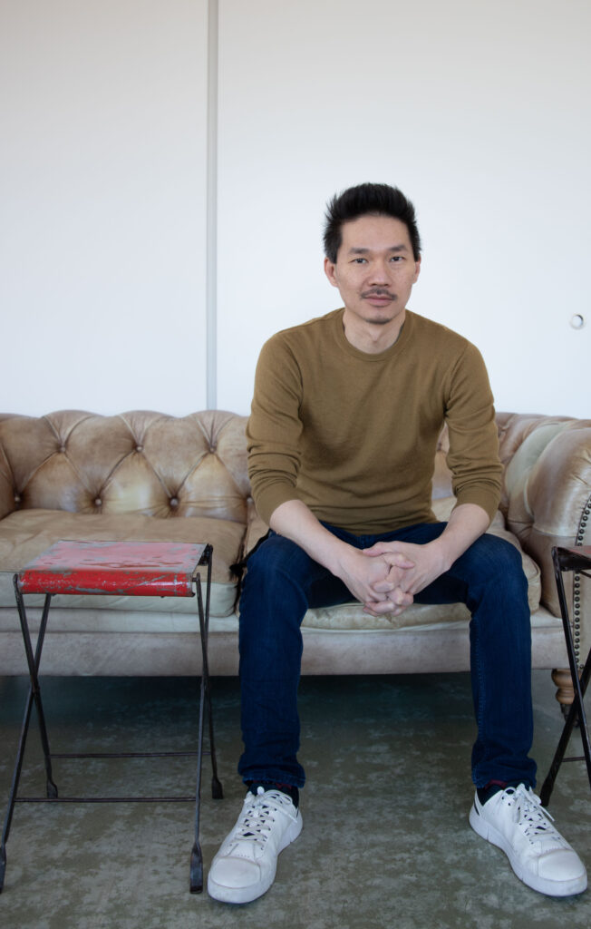 Man sitting on a leather couch in a bright room