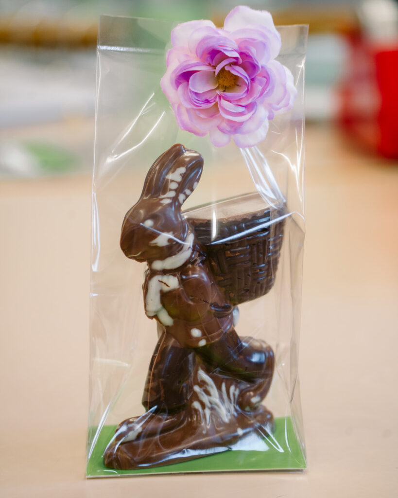 Schokoladen-Osterhase in Klarsichtfolie mit Blume
