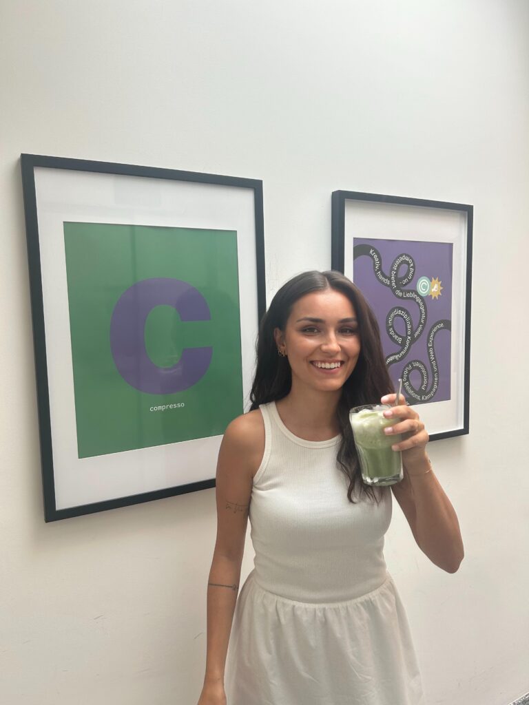 Chiara drinks green smoothie in front of artwork