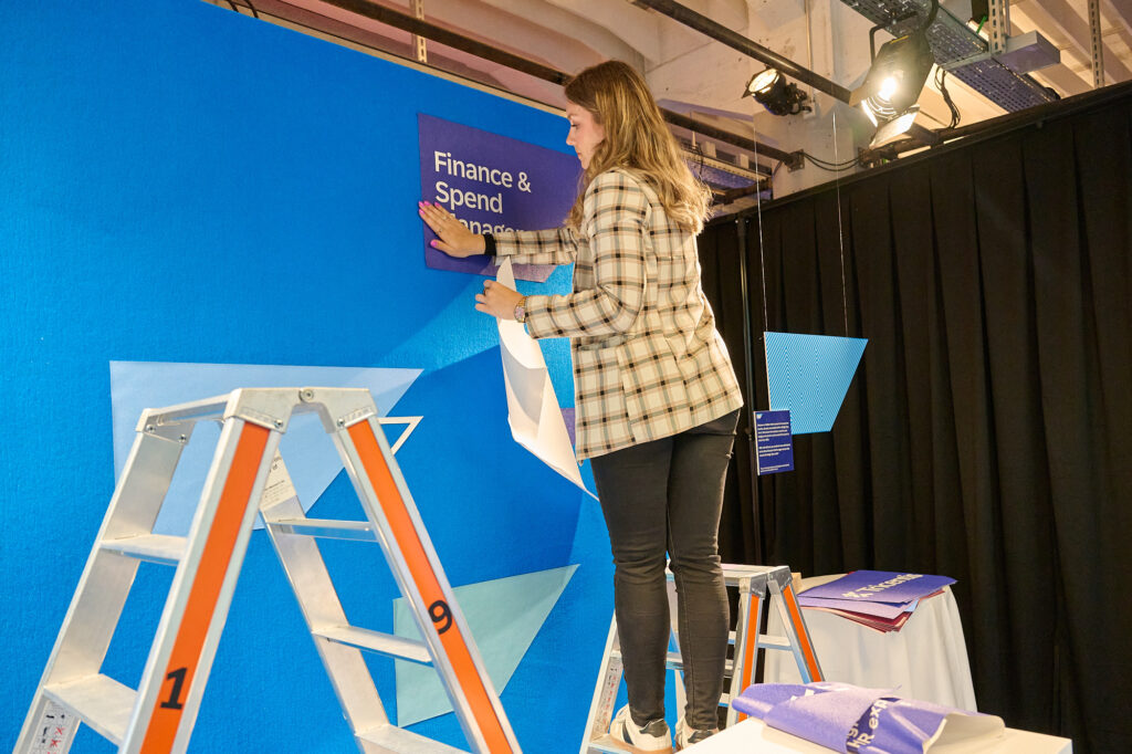 Chiara hängt Schild auf blauem Hintergrund auf.