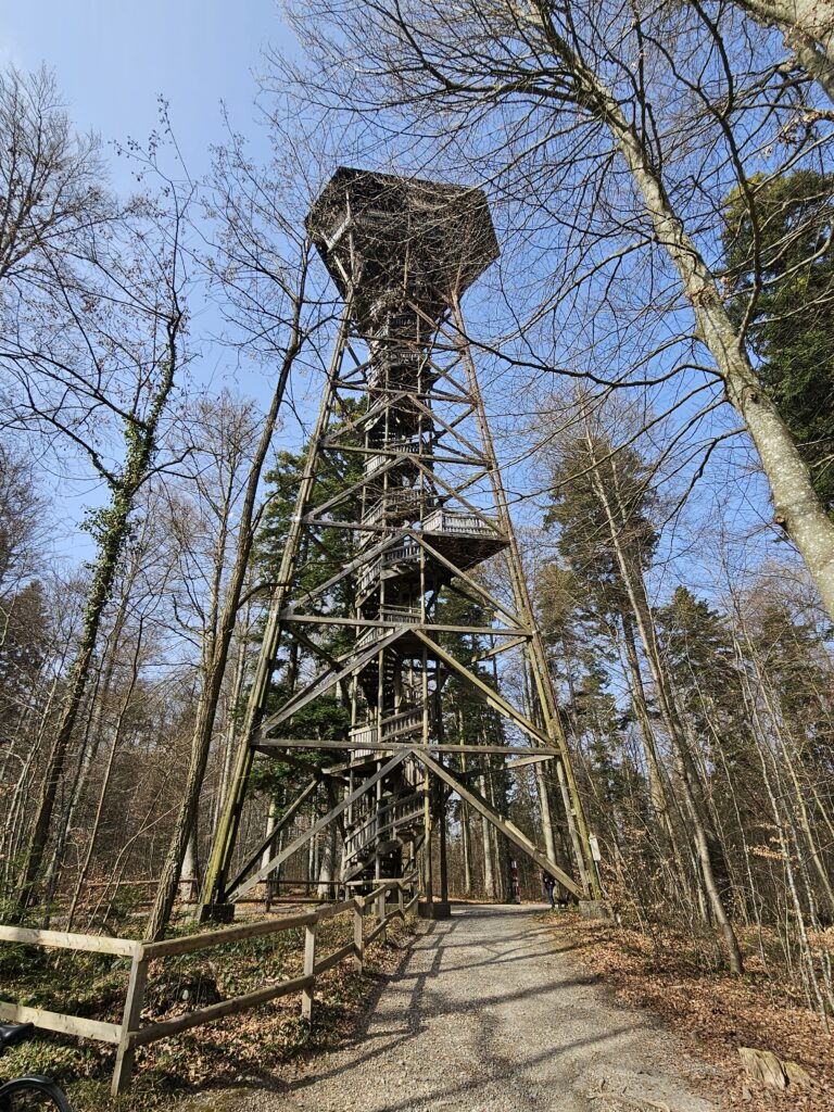 Holzturm im Wald unter blauem Himmel